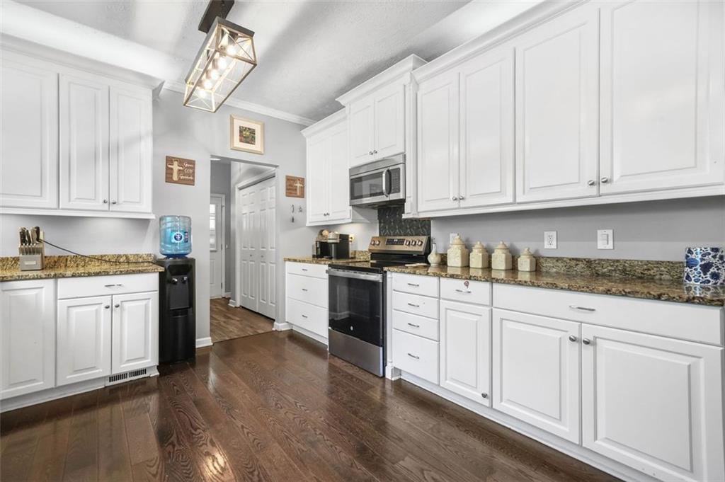 4835 Liberty Road Villa Rica, GA 30180 - Photo 18 of 72 a kitchen with granite countertop white cabinets and white appliances