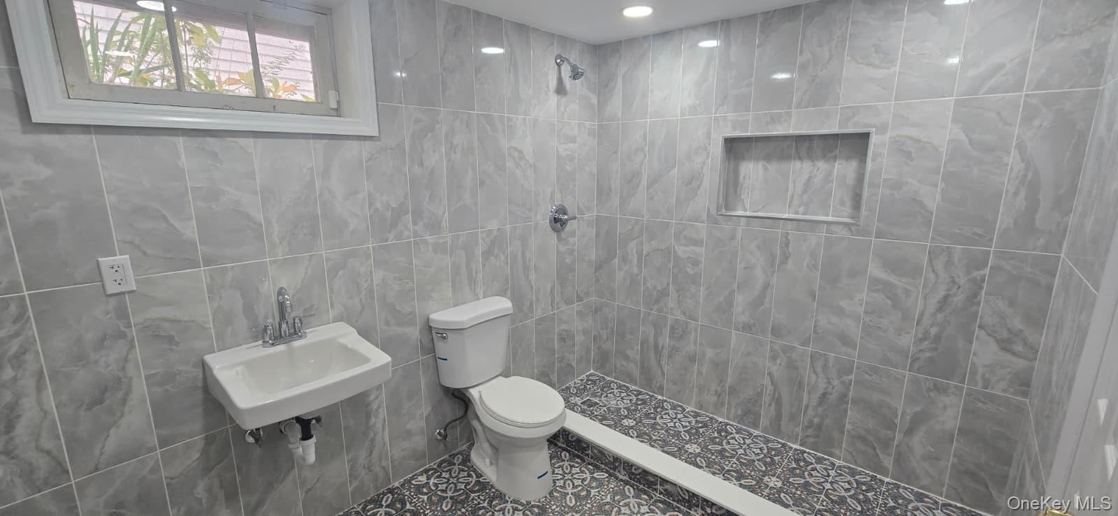 51 Peconic Street Selden, NY 11784 - Photo 3 of 16 a bathroom with a toilet a sink a shower and a window