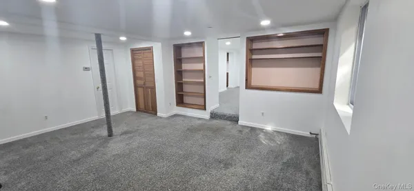 an empty room with closet and windows