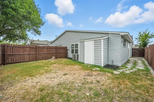 a view of backyard with wooden fence