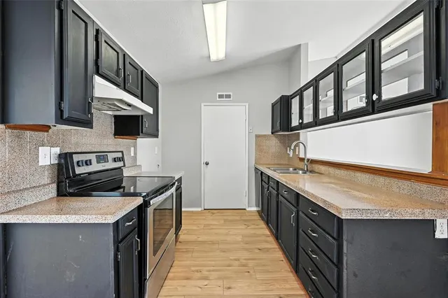 a kitchen with stainless steel appliances granite countertop a stove and a sink