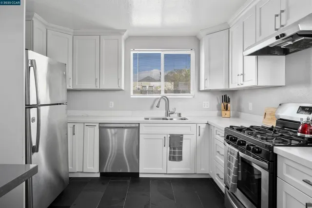 a kitchen with stainless steel appliances granite countertop a sink stove and refrigerator