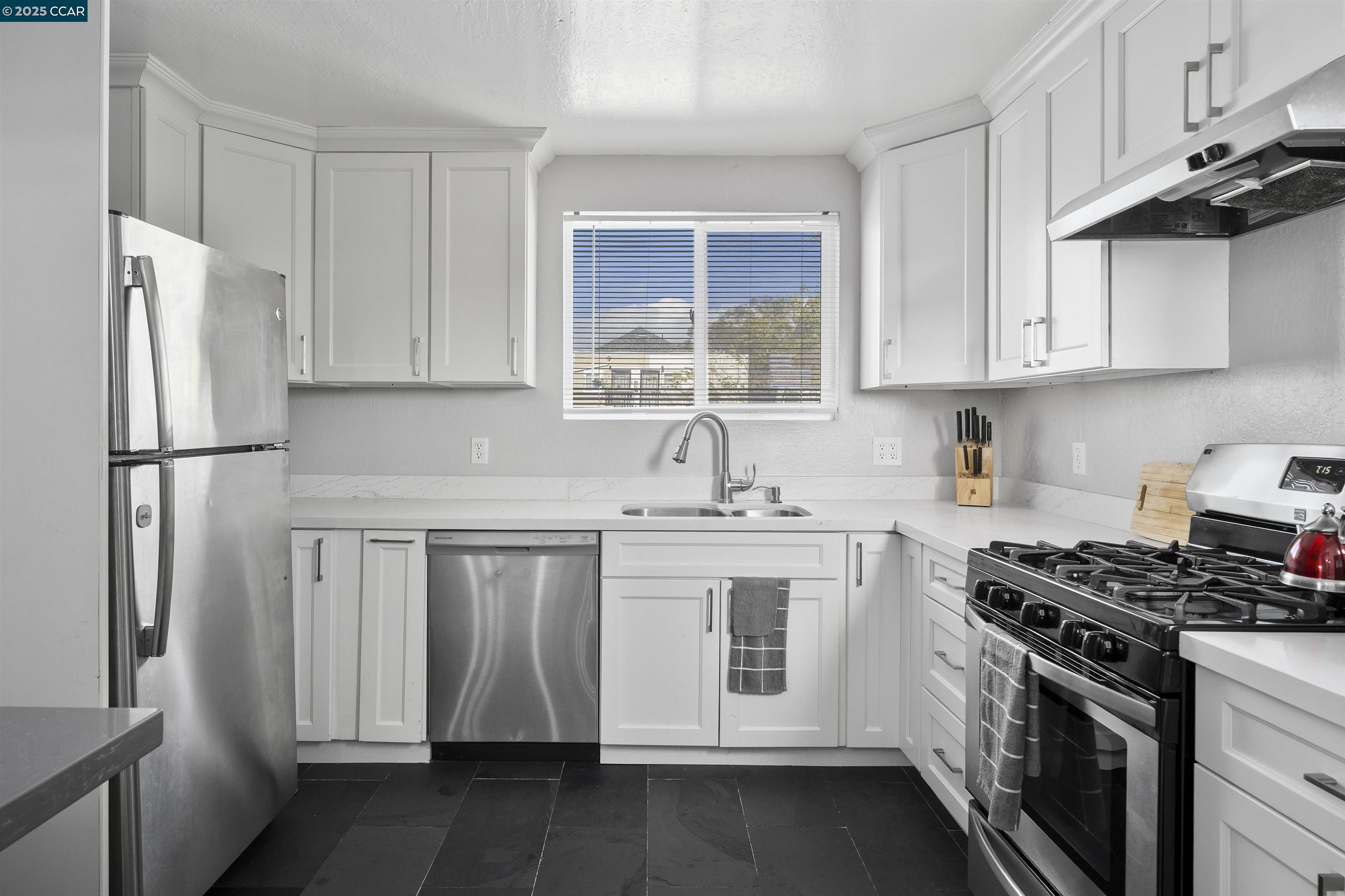 874 36th Street Oakland, CA 94608 - Photo 13 of 41 a kitchen with stainless steel appliances granite countertop a sink stove and refrigerator