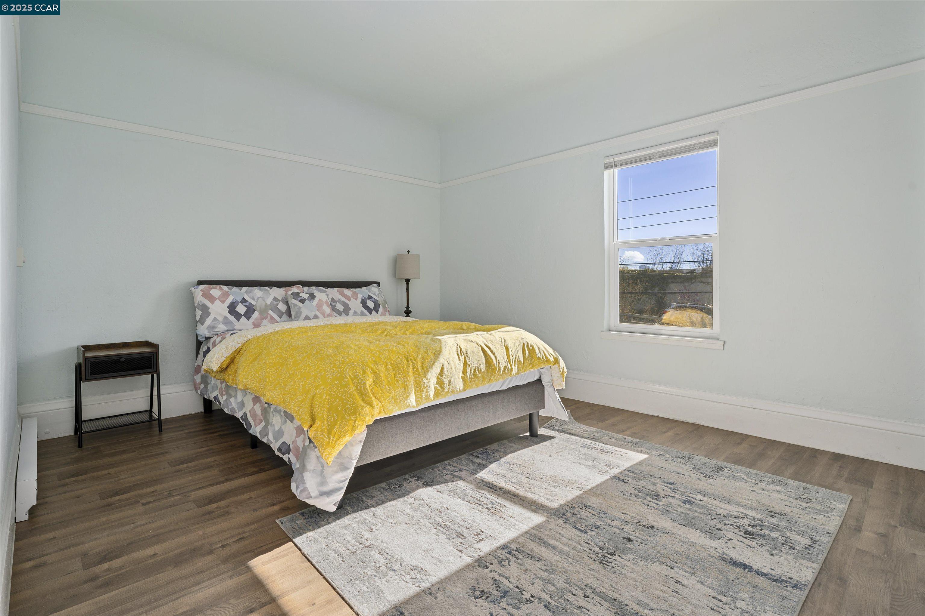 874 36th Street Oakland, CA 94608 - Photo 18 of 41 a bed sitting in a bedroom next to a window