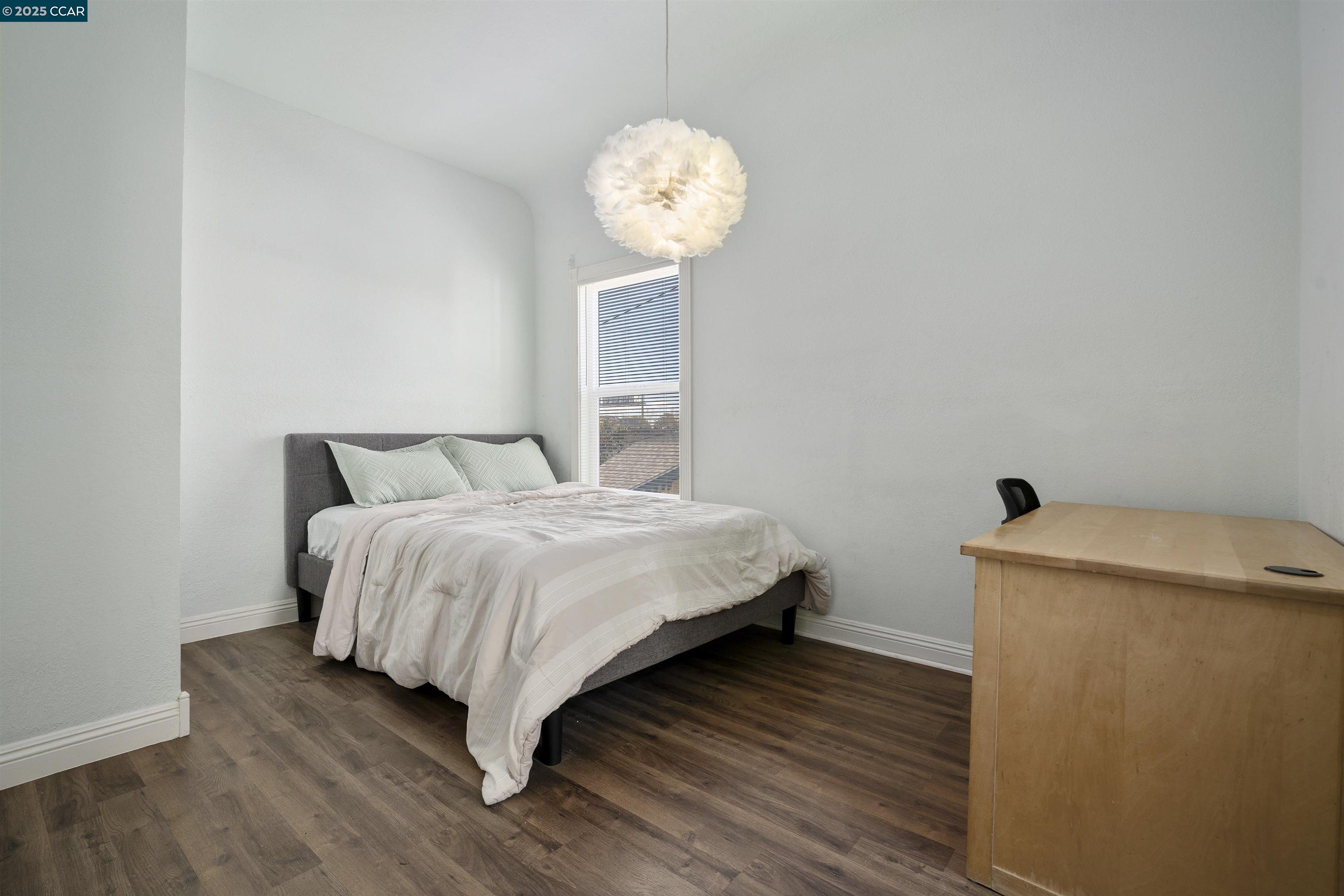 874 36th Street Oakland, CA 94608 - Photo 23 of 41 a bedroom with a bed and a chandelier