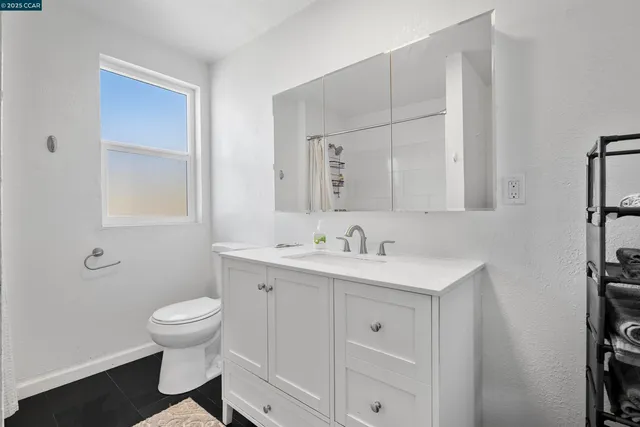 a bathroom with a toilet a sink a vanity and mirror