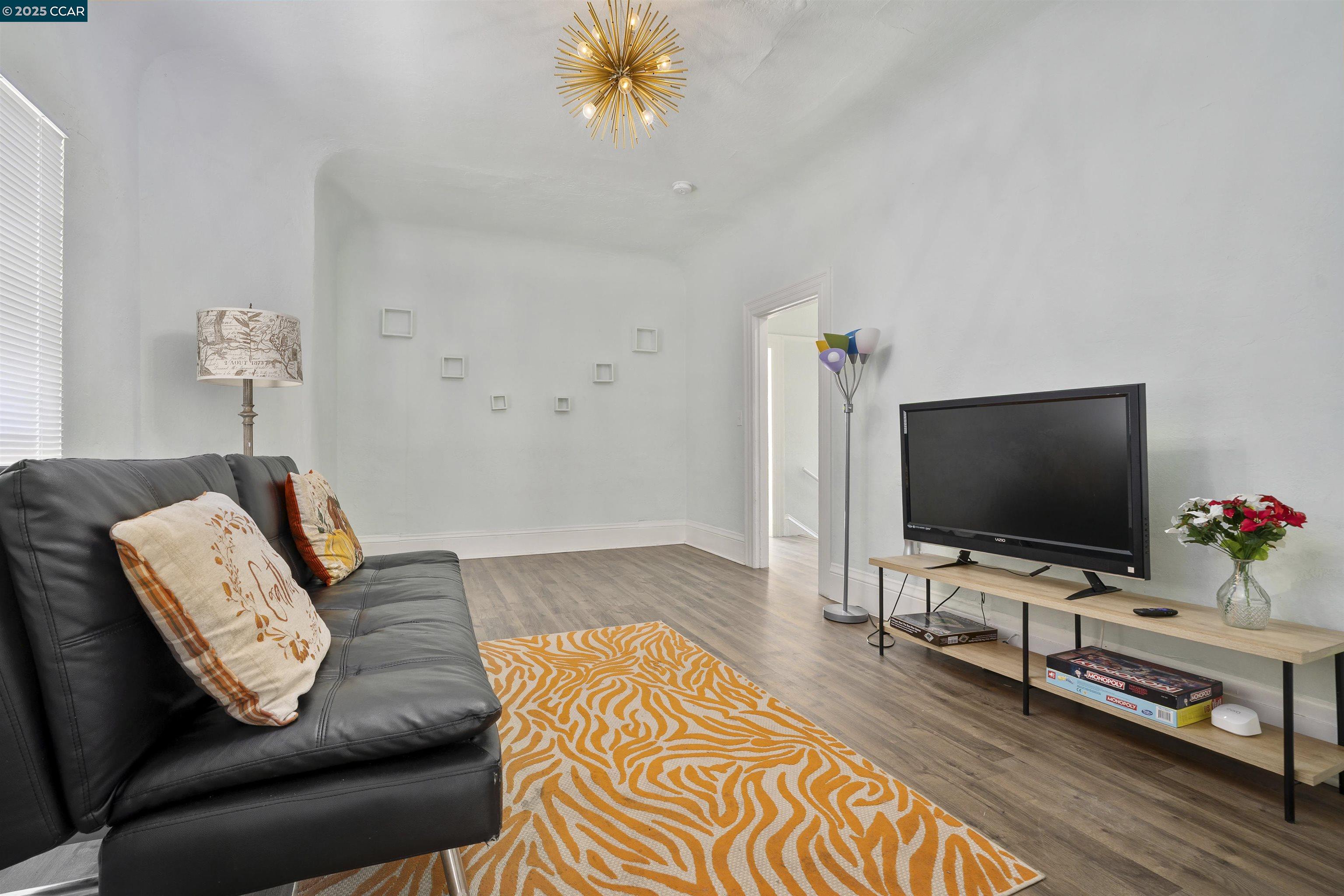 874 36th Street Oakland, CA 94608 - Photo 9 of 41 a living room with furniture and a flat screen tv