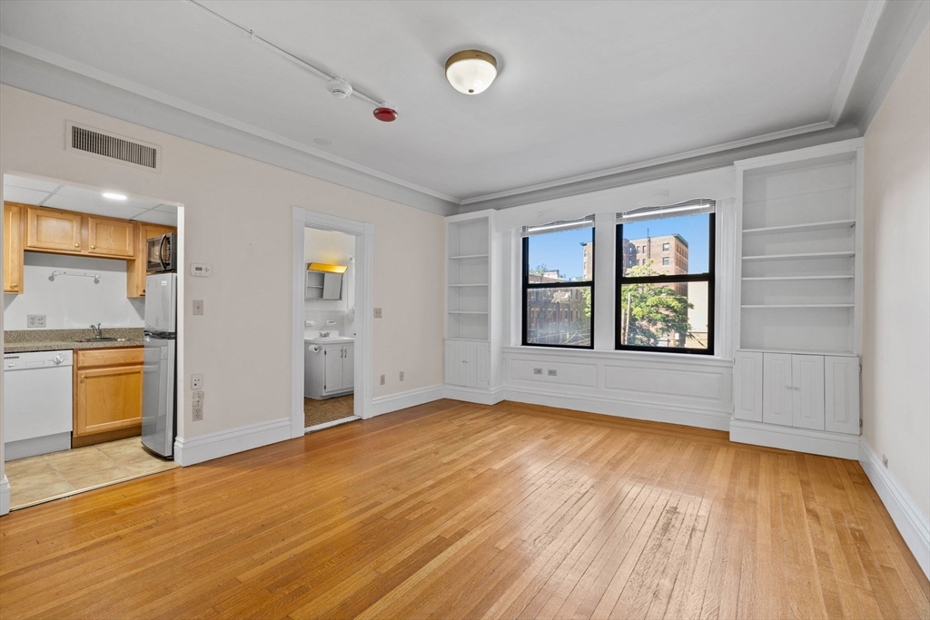 466 Commonwealth Avenue, Unit 305 Boston, MA 02215 - Photo 5 of 14 an empty room with a window and wooden floor