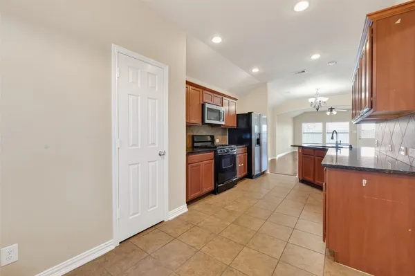 a large kitchen with stainless steel appliances a large counter top and a stove
