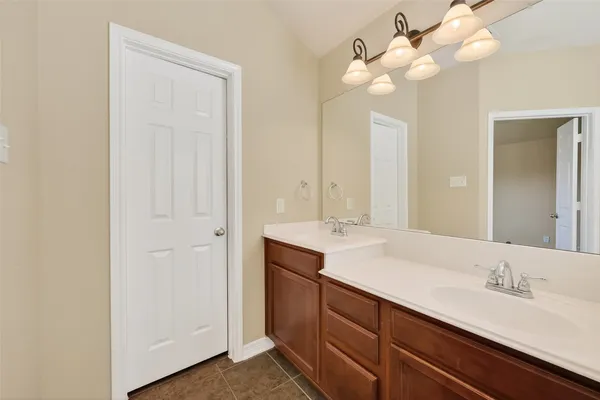 a bathroom with a double vanity sink and a mirror