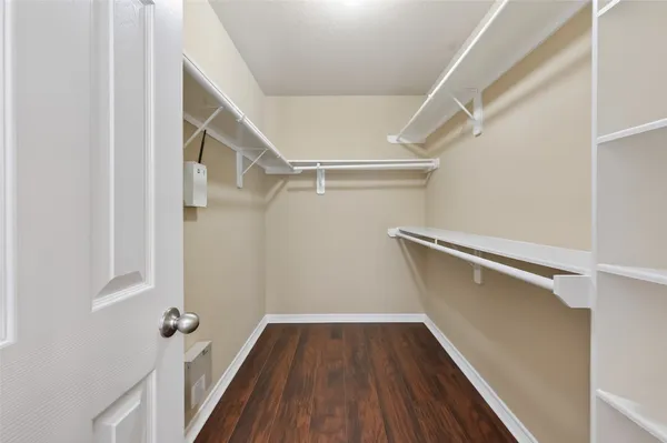 a view of walk in closet with wooden floor