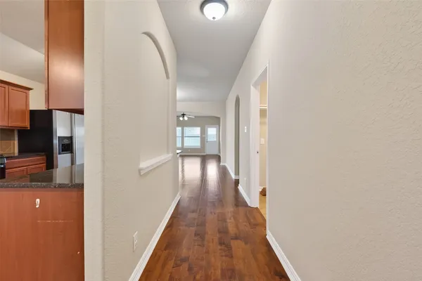 a view of a hallway with wooden floor