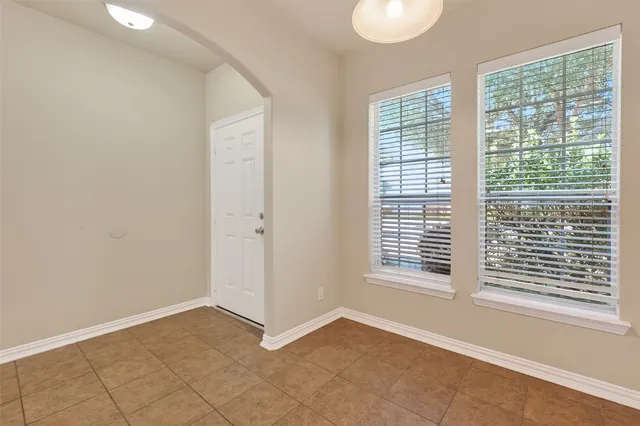 a view of an empty room with a window and a bathroom