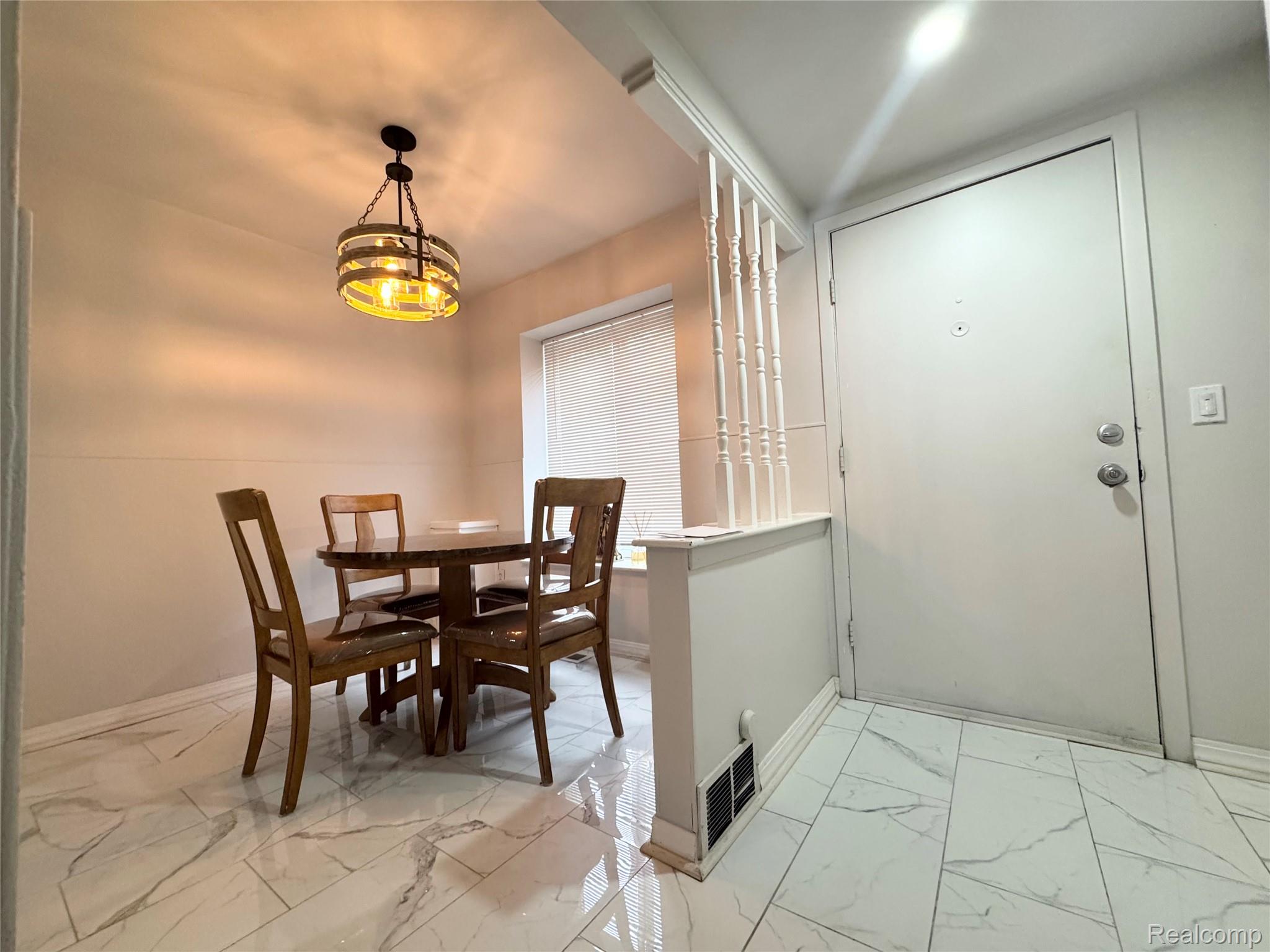 4386 15 Mile Road, Unit 64 Sterling Heights, MI 48310 - Photo 13 of 23 Entryway featuring white tile flooring with subtle veining, a white entry door with chrome hardware, and a half-wall with decorative spindles