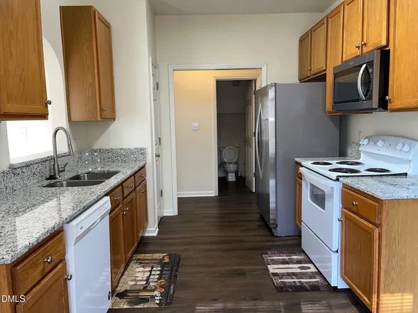 a kitchen with stainless steel appliances granite countertop a stove a sink and a refrigerator