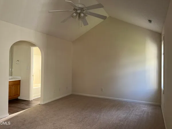 an empty room with a ceiling fan and a window