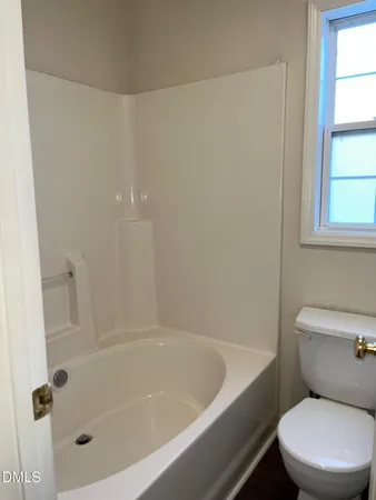 a white bath tub sitting next to a toilet