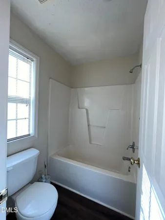a bathroom with a toilet bathtub and window