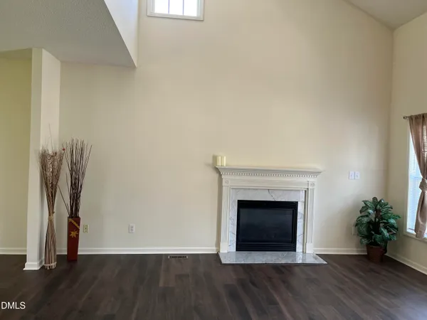 an empty room with wooden floor and a fireplace