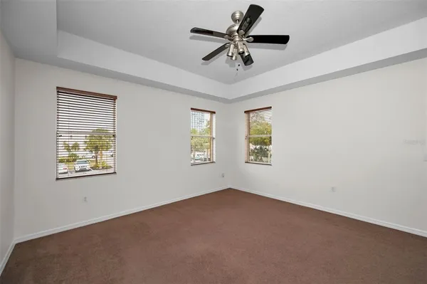 a view of a big room with a ceiling fan and window