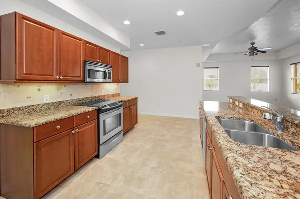 a kitchen with stainless steel appliances granite countertop a sink stove and microwave