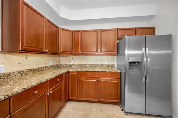 a kitchen with stainless steel appliances granite countertop a refrigerator and a sink