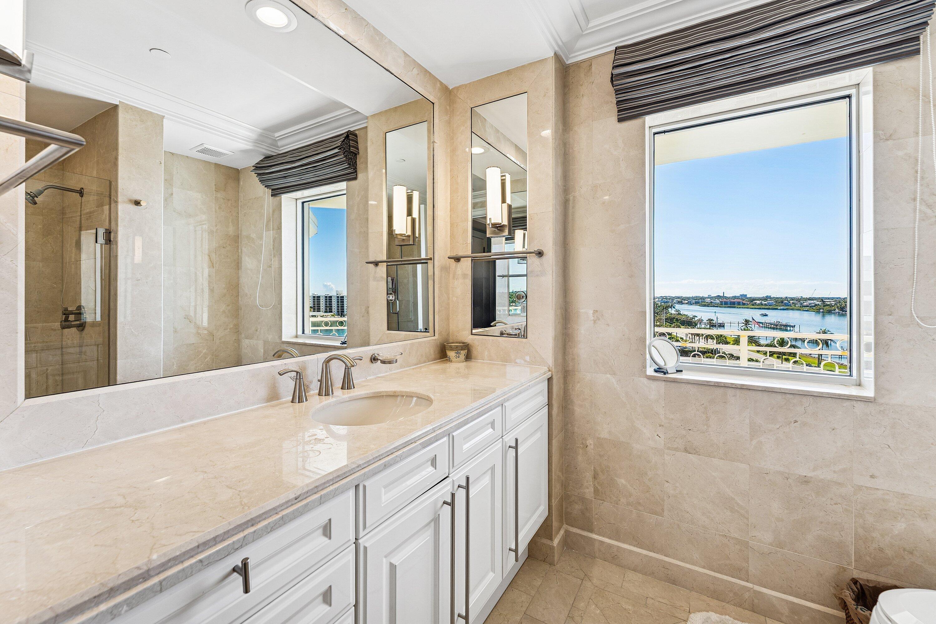 19950 South Beach Road, Unit 7S Jupiter, FL 33469 - Photo 17 of 40 a bathroom with a double vanity sink and a mirror