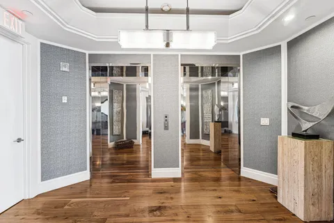 a view of a hallway with wooden floor and stairs