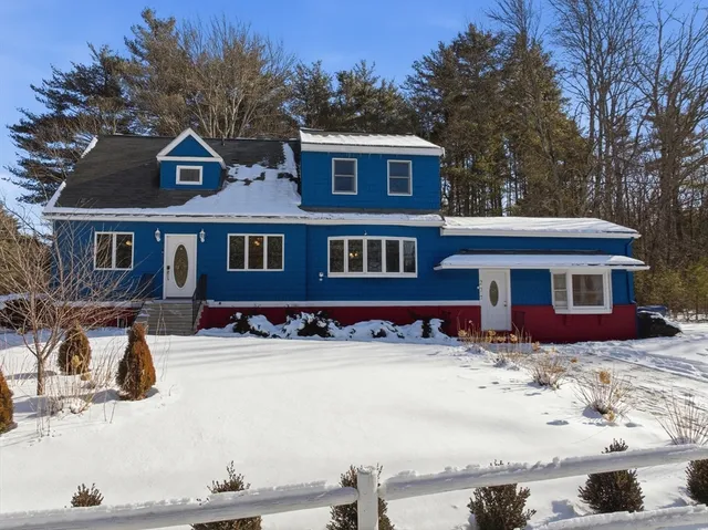 a front view of a house with a yard covered in snow