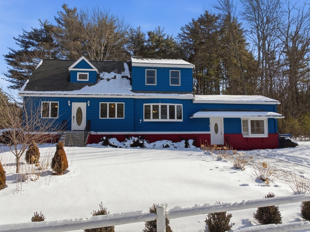 a front view of a house with a yard covered in snow