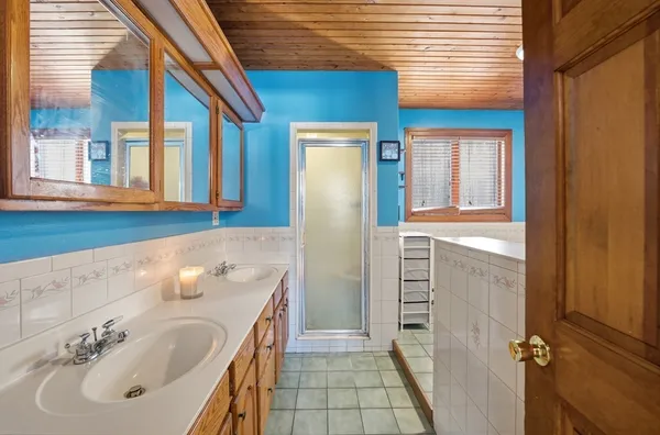 a bathroom with a tub sink and mirror