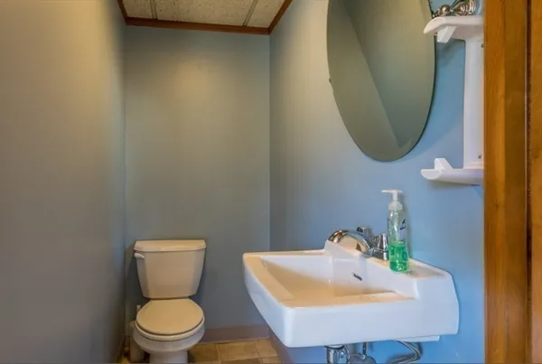 a bathroom with a toilet sink and mirror