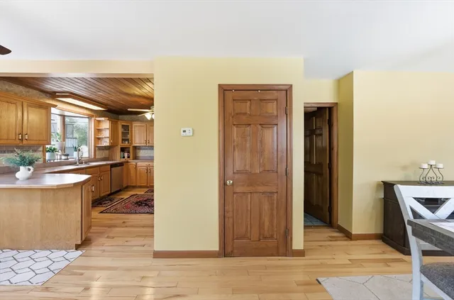 a living room with stainless steel appliances kitchen island granite countertop a refrigerator and a sink