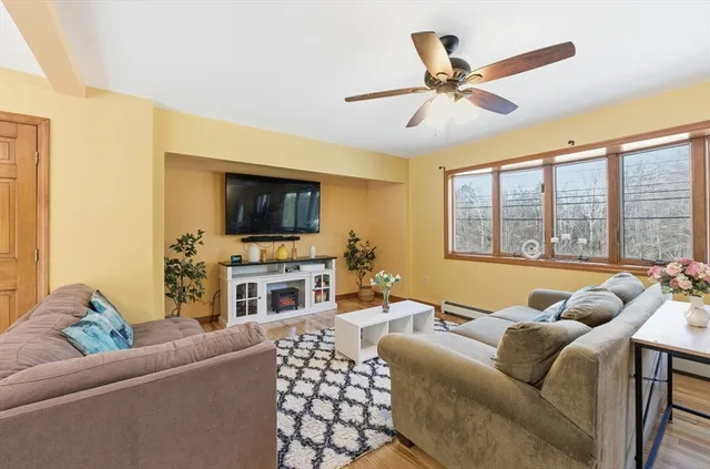 a living room with furniture and a flat screen tv with wooden floor