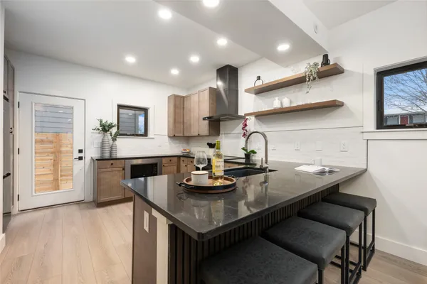 a kitchen with granite countertop a table chairs stove and cabinets