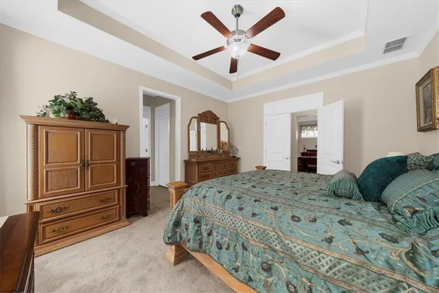 a spacious bedroom with a bed and a chandelier