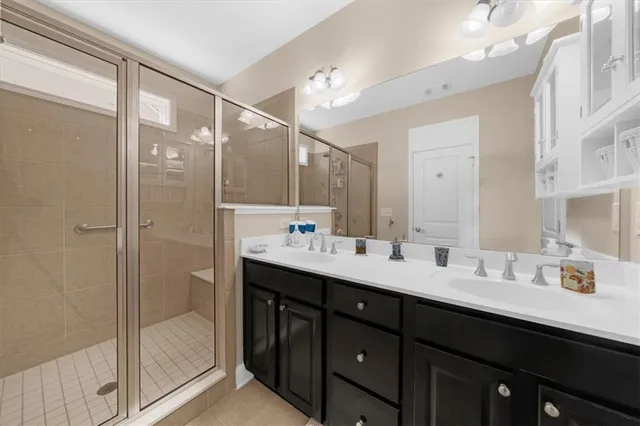 a bathroom with a double vanity sink mirror and shower