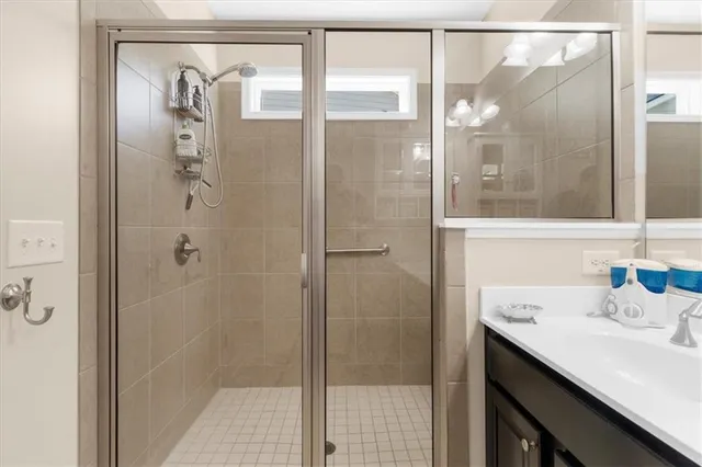a bathroom with a shower sink and mirror