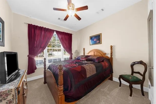 a bed room with a bed tv and a window