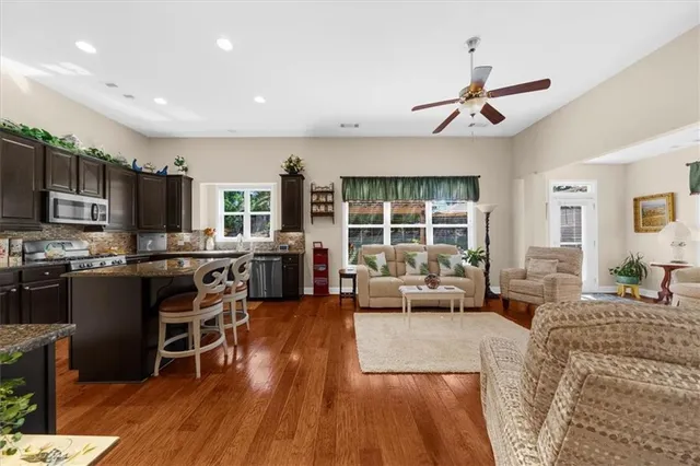 a living room with stainless steel appliances furniture and a kitchen view
