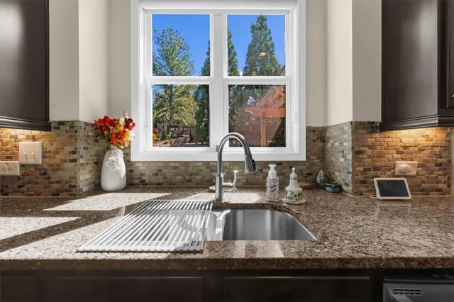 a kitchen with granite countertop a sink and a stove