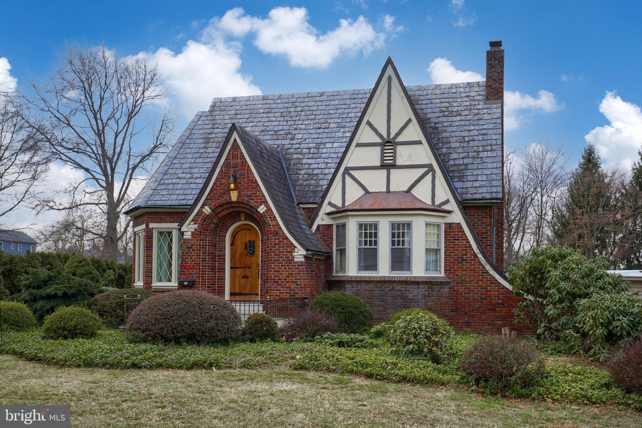 620 South Spruce Street Lititz, PA 17543 - Photo 1 of 57 a view of a brick house with large windows and a yard with plants and large trees