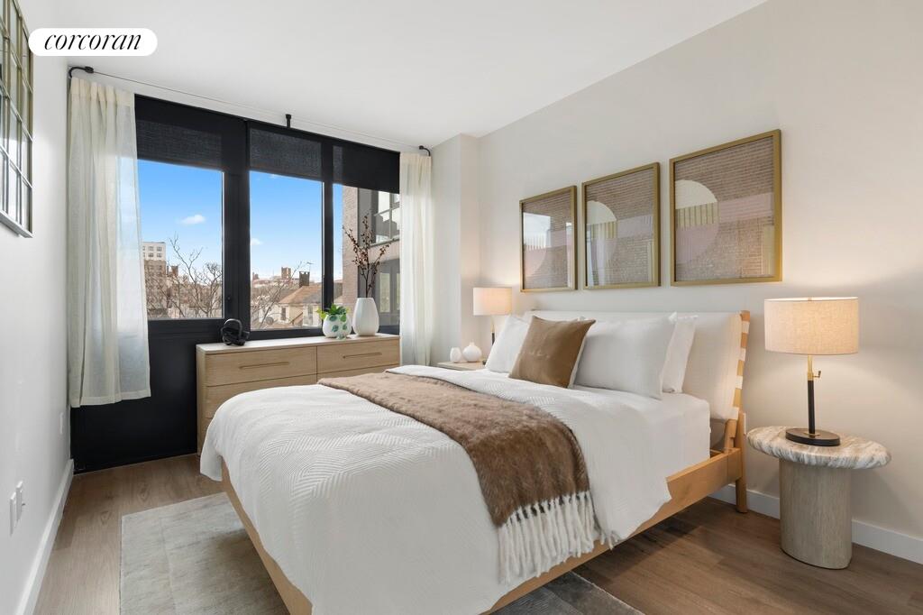 166-20 90th Avenue, Unit 357 Queens, NY 11432 - Photo 6 of 15 a bedroom with a large bed and a large window