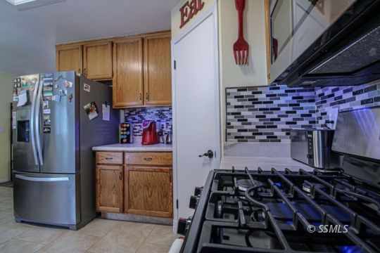 324 Sims Street Ridgecrest, CA 93555 - Photo 15 of 40 a kitchen with stainless steel appliances granite countertop a stove and a refrigerator
