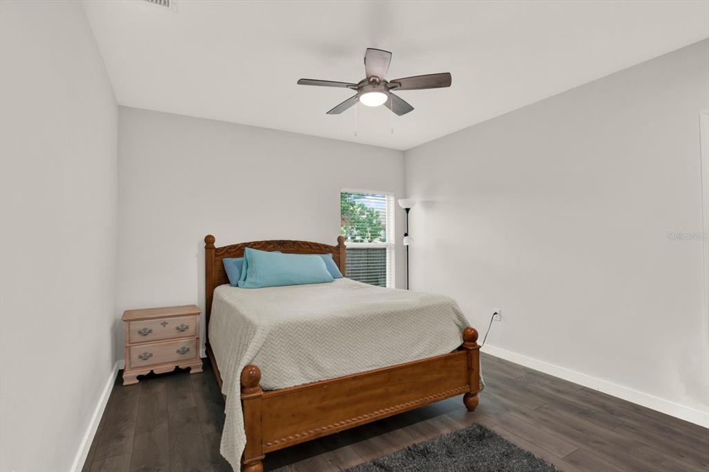 3023 Muir Street Holiday, FL 34691 - Photo 16 of 25 a bedroom with a bed and a chandelier
