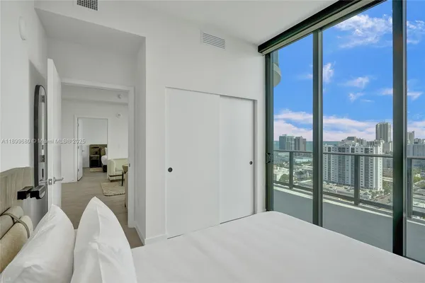 a bedroom with a bed and a large window