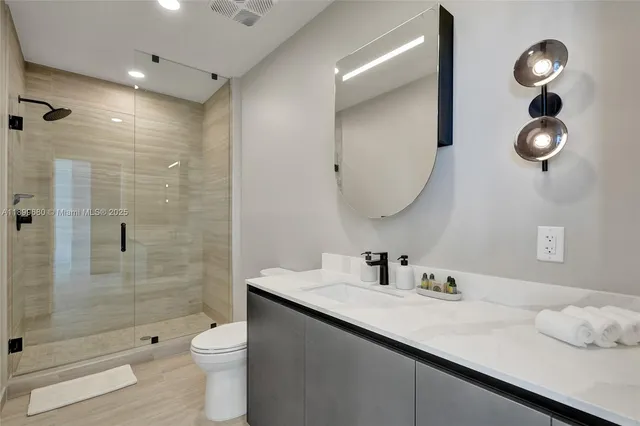 a bathroom with a double vanity sink toilet and shower