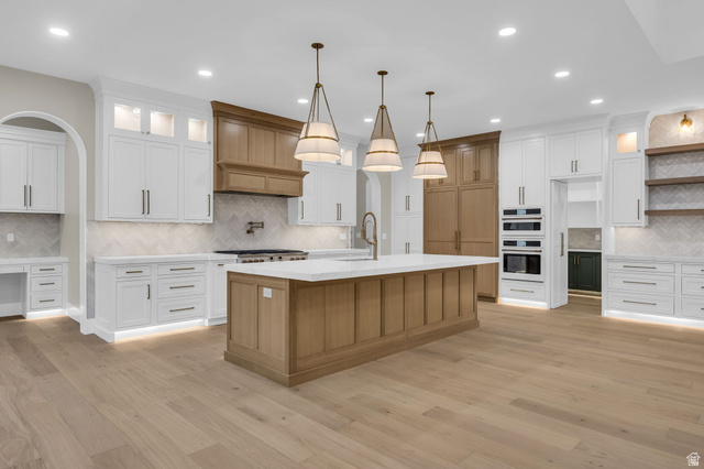 2828 Jojo Road Eagle Mountain, UT 84005 - Photo 10 of 63 Expansive kitchen featuring a large central island with a light wood-finish base and light-toned countertop, complemented by three pendant light fixtures