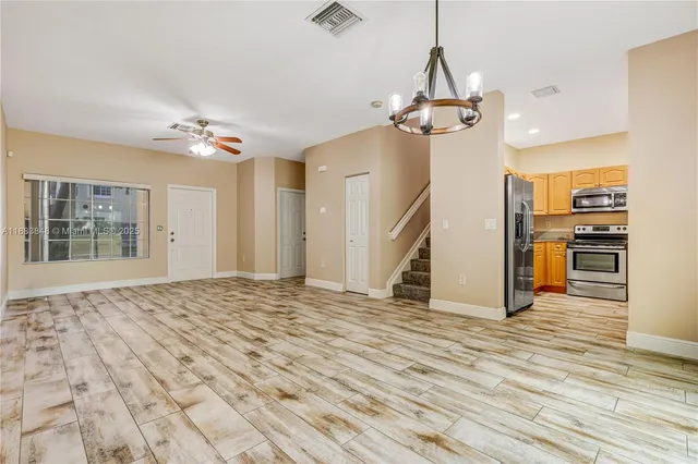 a view of a kitchen with wooden floor and a ceiling fan