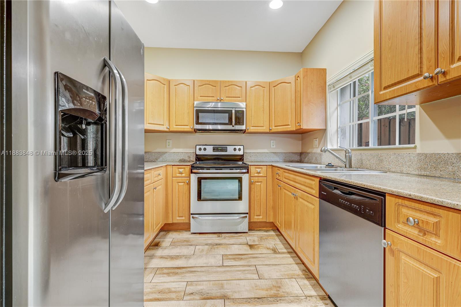 7627 East Stonecreek Circle Davie, FL 33024 - Photo 5 of 29 a kitchen with stainless steel appliances granite countertop a refrigerator a stove and a sink
